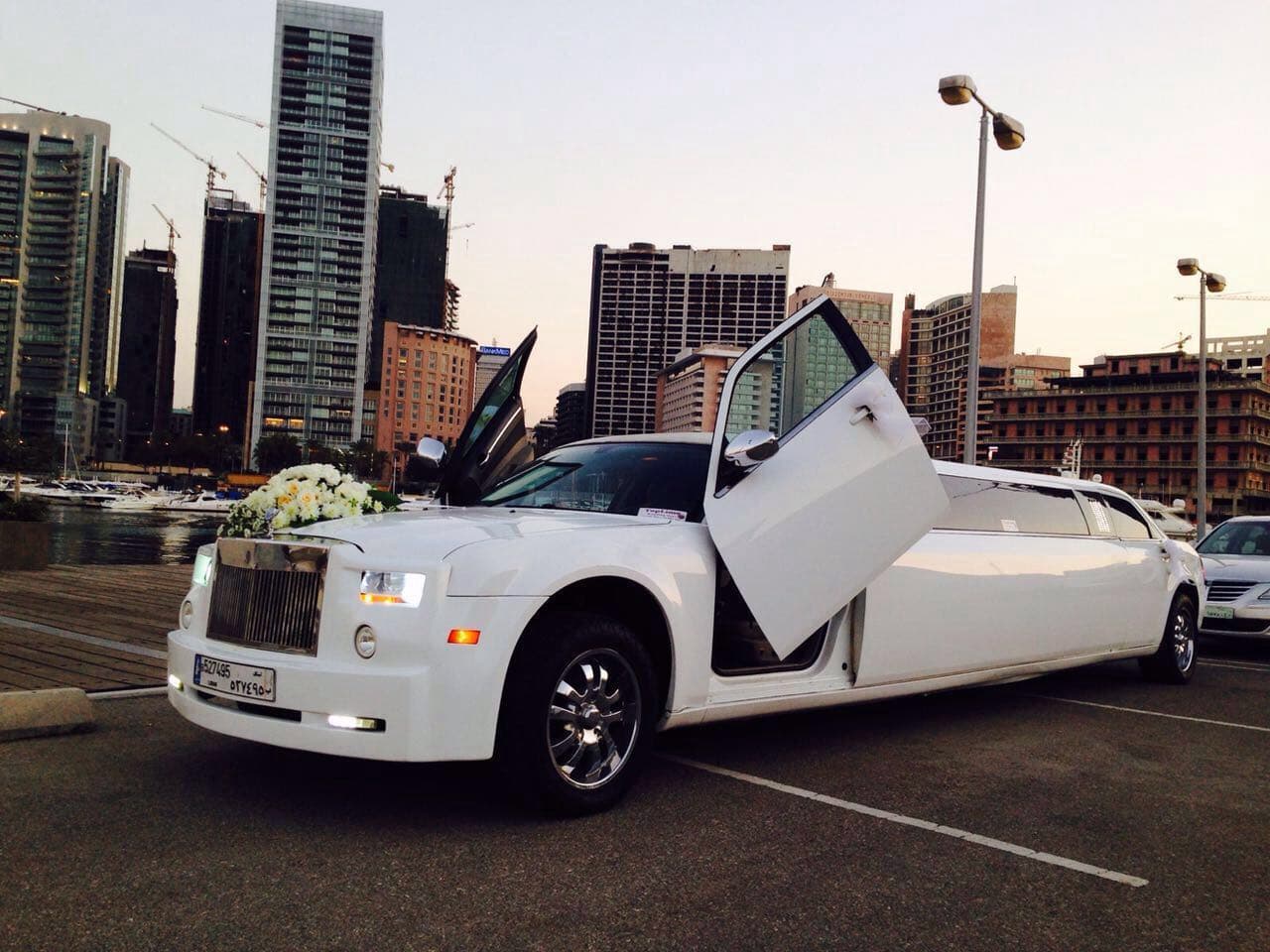 White wedding limousine phantom car with bridal flowers decoration