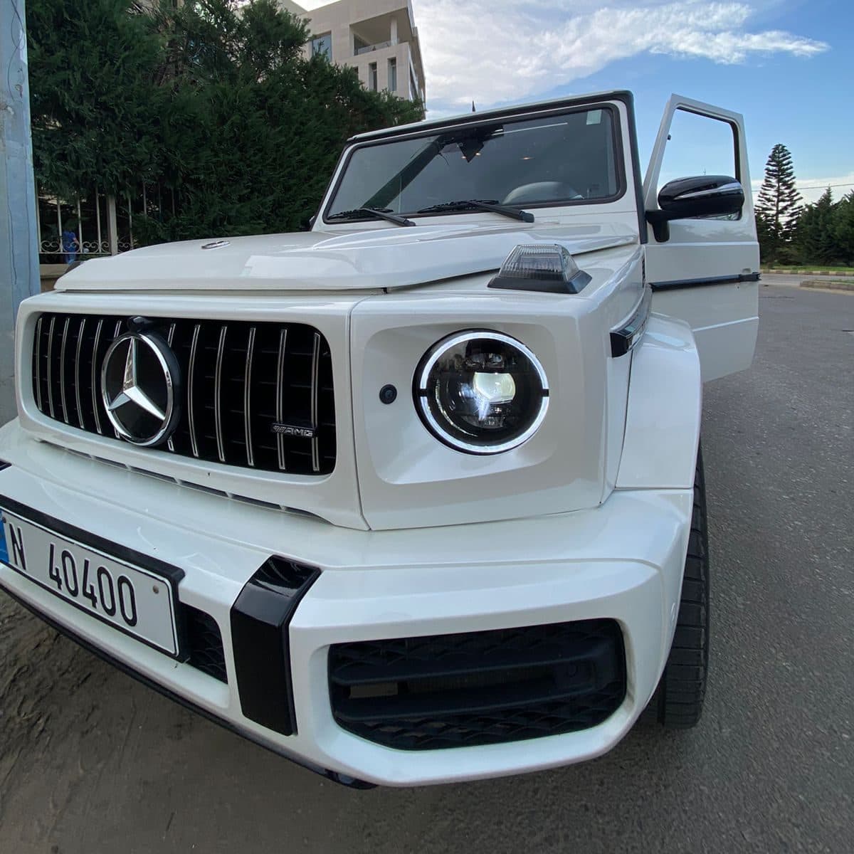 The front of the Luxury white Mercedes G class with the front door open