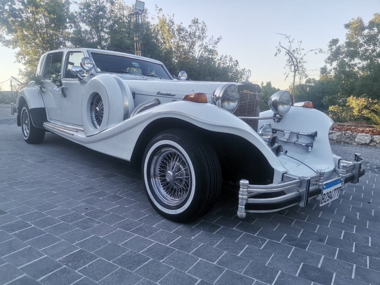 The front of the original Excalibur sedan photo taken in a village in Beirut next to trees