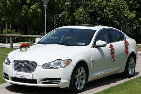 White Jaguar XF with wedding decoration in red
